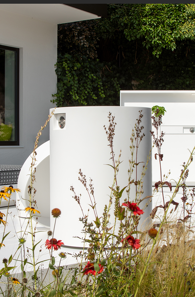 Ein elektrischer Teriyaki-Grill, eingefasst in eine runde HIMACS-Verkleidung, bildet das Herzstück dieser Outdoor-Arrangements.